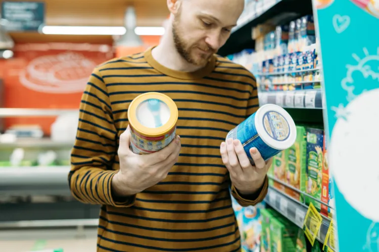 man reading labels on food products in the grocery store